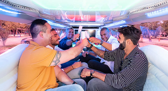 Bachelor party with group of friends having fun inside a stretch limousine by Mundi Limos