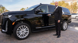 Professional driver with his hand on the door handle of a black SUV