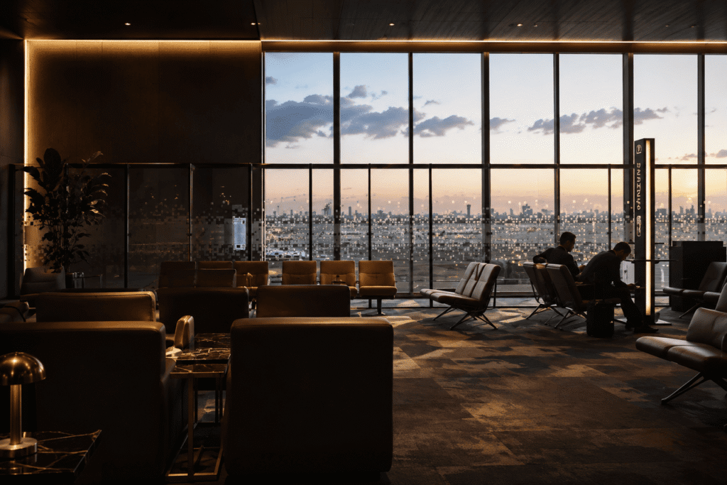 Luxurious VIP airport lounge at Benito Juárez International Airport (MEX) featuring elegant seating, warm ambient lighting, and floor-to-ceiling windows overlooking the airfield at sunset.